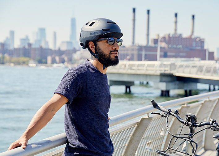 Man wearing Matte Navy Hudson with flip visor gazing toward the city along the Hudson river New York, New York.